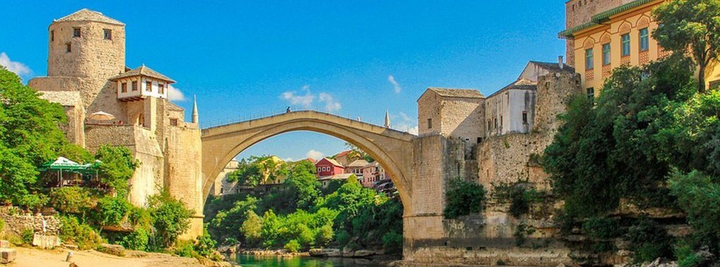 Fluss in Bosnien mit mittelalterlicher Brücke darüber 