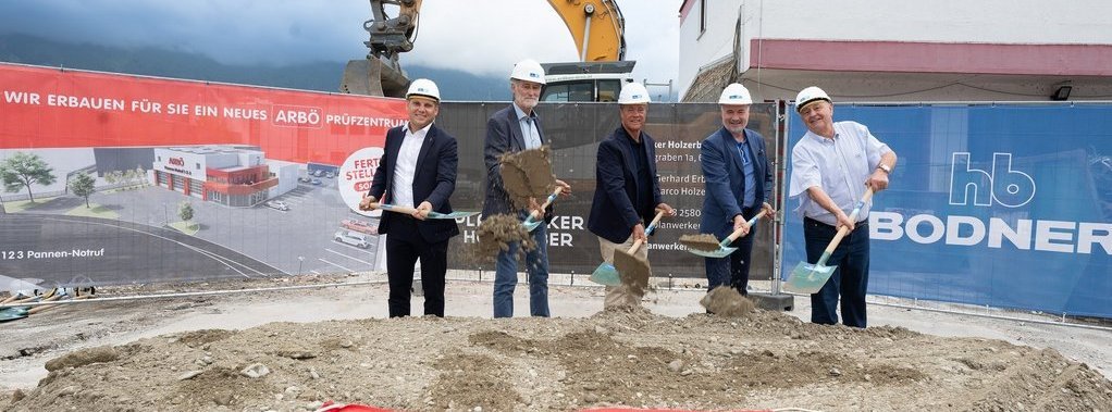 © ARBÖ Fünf Personen mit Bauhelm halten einen Spaten mit Erde in der Hand und lächeln in die Kamera.