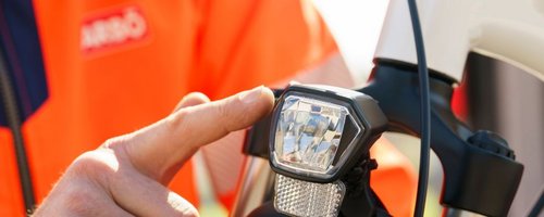 Bildausschnitt von einem ARBÖ-Techniker, der auf das Fahrradlicht zeigt