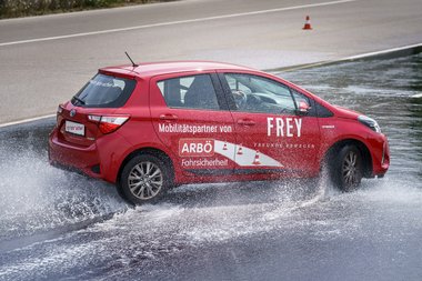 Auto fährt durch Wasserhindernis.