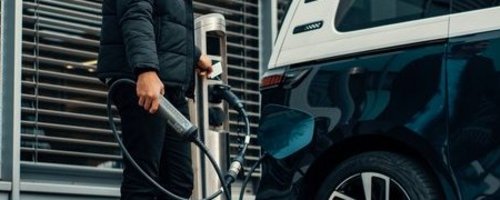 Junger Mann lädt sein Elektroauto