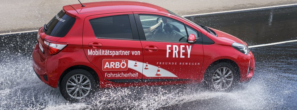 Auto fährt im Fahrsicherheits-Zentrum durch ein Wasserhindernis.