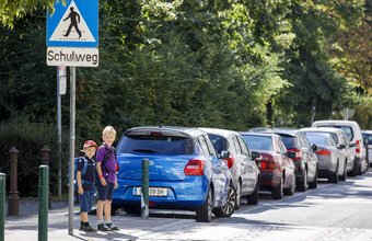 Zwei Schulkinder wollen die Straße an einem Schutzweg überqueren