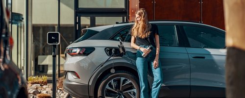 Junge Frau lädt ihr E-Auto