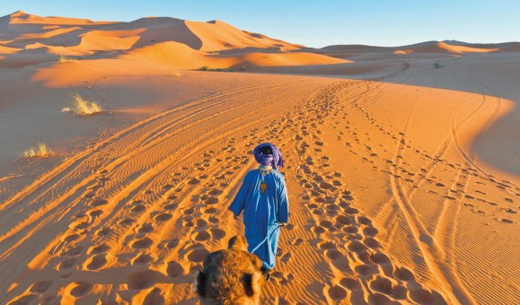 Wüstenlandschaft in Marokko, Berber mit führt Kamel