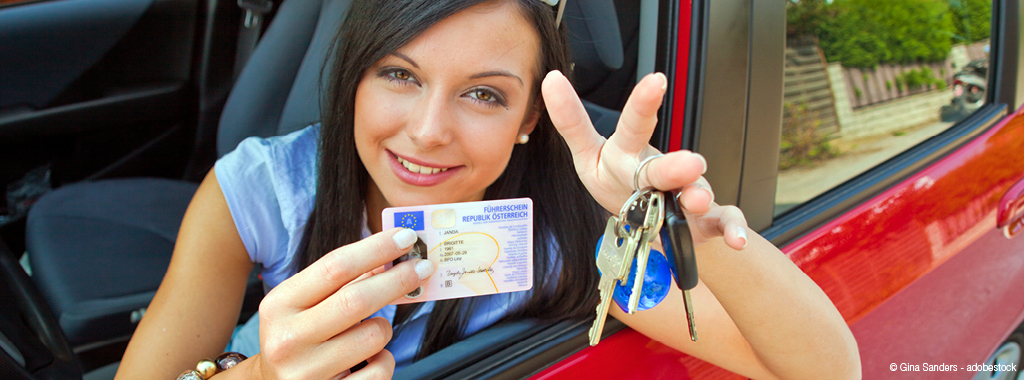 Junge Frau zeigt ihren neuen Führerschein