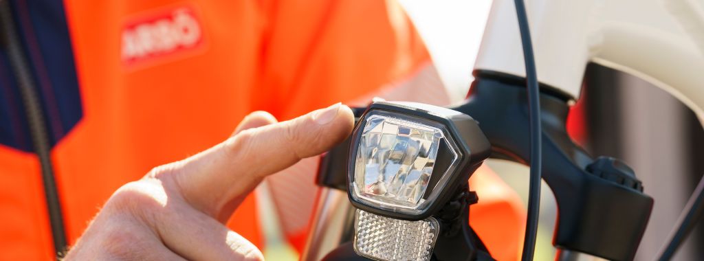Bildausschnitt von einem ARBÖ-Techniker, der auf das Fahrradlicht zeigt