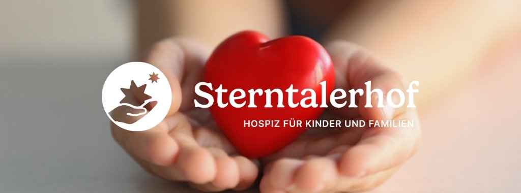Kinderhände halten ein rotes Herz. Davor ist das Sterntaler-Logo zu sehen.