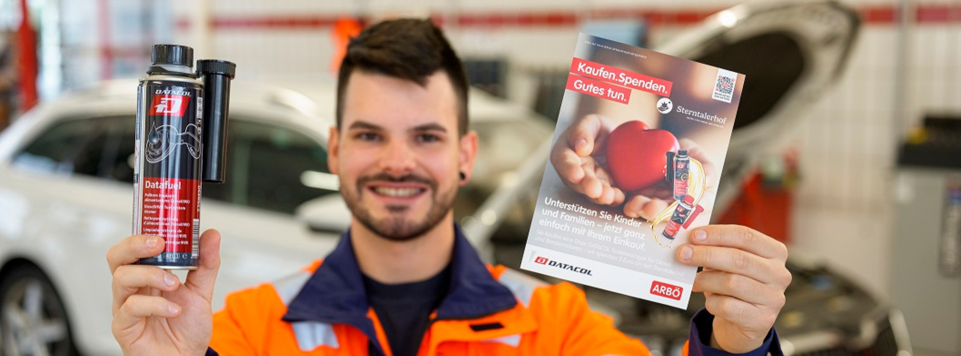 ARBÖ-Techniker hält Aktionsflyer und DATACOL-Dose in die Kamera.